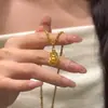2026 Llamativo Lujoso Collar con Borlas Cadena Dorada Hueca para Clavícula Elegante Colección de Alta Gama Collar Flor de Iris