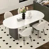 Mesa de comedor de color crema, moderna y lujosa con tapa de piedra para uso doméstico, con un diseño moderno y minimalista de forma ovalada negra, adecuada para comedores