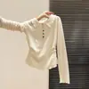 Camiseta básica de mujer para principios de primavera, manga larga, cuello polo, semitransparente, con textura y un borde con volantes que ciñe la cintura.