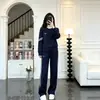 Atuendo de moda estilo coreano: un conjunto completo de OOTD con un conjunto deportivo casual con sudaderas bordadas de cuello redondo y pantalones de pierna ancha