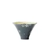 Taza de té pintada a mano con patrón floral blanco y diseño de sombrero de bambú, con un estilo delicado y refinado, perfecta para disfrutar del té en casa en un ambiente inspirado en el Zen.