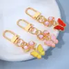 Lindo Colgante Llavero de Aleación Mariposa Colgante Creativo de Zirconia Lazo Corazón de Niña Colgante para Cubierta de Auriculares Bolsa
