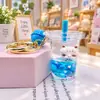Perro blanco pequeño azul flotando en aceite, figura de cachorro en una botella de arena líquida, llavero de muñeca de dibujos animados lindo, regalo