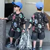 Conjunto de Roupa de Verão para Meninos 2026 Novo Verão Infantil Desenho Animado Dinossauro Camiseta de Manga Curta Meninos Shorts Jeans Estilosos Camiseta