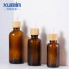 Envase Xumin en stock botella de aceite esencial marrón de 30 ml botella de vidrio con gotero con veta de madera de 50-100 ml sub-botella de cosméticos