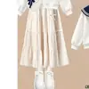 Conjunto de duas peças estilo preppy para meninas para o início do outono: moletom estiloso com gola Peter Pan, laço e saia branca em camadas