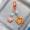 Hebilla de puerta G05 nuevo acrílico hueco brillante estrella de cinco puntas llavero para coche colgante crema dos colores campanilla a juego