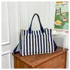 Bolsa de tela de moda de comercio exterior 2026 Nueva primavera Gran capacidad Bolsa de lona Tote para ir al trabajo Informal Transfronteriza Manual de mano Hombro