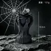 Calavera negra de Halloween sosteniendo una vela perfumada de rosa, vela decorativa con forma de calavera para ambiente de fiesta navideña
