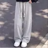Conjunto versátil de duas peças para meninas 2026, apresentando um top com capuz em blocos de cor combinado com calças simples, casuais e de cor sólida.