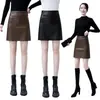 Falda de cuero versátil, falda de cuero mini PU negra para mujer otoño e invierno 2023, falda de línea A de cintura alta, falda corta ajustada, transfronterizo