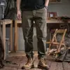 Nueva colección primavera 2026: Pantalones de trabajo modernos, minimalistas y casuales para hombre, con un corte relajado y tobillos cónicos, en un estilo retro.