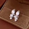 Pendientes de borla con flor de trébol de circonita vintage con un toque de alta gama, pendientes versátiles y de moda al por mayor
