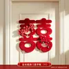 Nueva decoración de habitación de bodas estilo chino, con caracteres auspiciosos, decoraciones festivas para puertas, borlas y arreglos florales, creando un telón de fondo pintoresco para las fotos de boda.