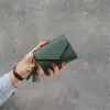 Bolsa de mano corta nueva de moda Primavera-Verano 2025, con colgante de corazón, moda casual, multifuncional, patrón de lichi, cartera para mujer