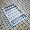 Mesa cuadrada de acero inoxidable con bordes biselados, con un diseño rectangular integrado y plegable, adecuada como mesa de trabajo o mesa de comedor