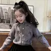Ropa infantil estilo coreano 2026 colección otoño e invierno nueva: Cárdigan de punto gris dulce con lazo para niñas y falda negra de terciopelo