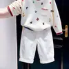 Suéter de malha estilo coreano para meninos, novo da moda outono 2026, com estampa de desenho animado, letras e blocos de cor, e calça casual branca para crianças, moderno