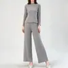 Conjunto plissado minimalista estilo japonês inspirado em Miyake, cor sólida com padrão sutil, top de manga longa com gola redonda, calça pantalona fluida, conjunto de duas peças casual para o outono