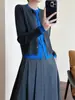 Elegante cárdigan de punto de lana merino con tapeta de doble capa de color contrastante y diseño de chaqueta doble falsa