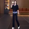 Elegante atuendo de otoño para mujer: un conjunto de dos piezas que incluye una sudadera de retazos a rayas con cuello, y pantalones de pierna ancha, diseñados para ser favorecedores, versátiles y casuales
