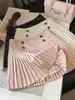 Falda corta de lana estilo coreano con hebilla dorada para mujer 2026 Otoño/Invierno Nueva falda plisada de línea A versátil de cintura alta adelgazante anti-exposición