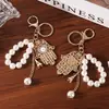 Llavero del Mal de Ojo con Cadena de Perlas de Imitación y Colgante de Palma Tachonado de Diamantes, Colgante Azul para Bolso de Mujer, Pequeño Regalo