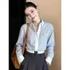 Camisa polo listrada em azul e branco estilo francês com design de ombro ajustado, nova coleção outono 2026 feminina, uma blusa sofisticada e estilosa para o trabalho