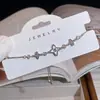 Pulseira Branca de Madrepérola de Luxo Leve para Mulheres, Design de Nicho de Alto Padrão, Flor de Quatro Folhas, Zircônia em Forma de Coração, Joia de Mão Ajustável Venda por Atacado