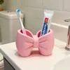 Portacepillos de dientes con forma de lazo, soporte de almacenamiento de plástico sin instalación, adorno de exhibición de bolígrafos y cepillos de dientes para baño y dormitorio