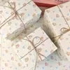 Una variedad de lindos papeles de regalo de dibujos animados para regalos navideños, materiales de embalaje para cajas de regalo, papel de regalo mixto de alta apariencia