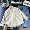 2026 Nueva Colección Otoño Ropa Infantil: Camisa Blanca Pura de Manga Larga Estilo Japonés Holgada Versátil con Cuello Alto para Niños Nantong Venta al por Mayor