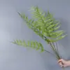 Plantas verdes artificiales en stock, manojos de helecho, hojas de helecho, hierba de helecho para decoración de paredes interiores y diseño de paisajes, césped artificial al por mayor