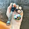 Llavero creativo de concha pequeña con aceite, lindo colgante pequeño de arena movediza líquida, accesorios para bolso, pequeño colgante de regalo, venta al por mayor