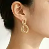 Pendientes elegantes de estilo europeo y americano para mujer, pendientes de botón dorados de moda con figura de ocho versátil, pendientes colgantes de metal de alta gama transfronterizos para mujer