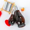 Botella spray oscura de calabaza única marrón envase de cosméticos botella de vidrio vacía botella de emulsión con dispensador marrón en stock al por mayor