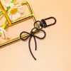 Llavero de lazo de cuentas estilo INS de colores con cinta, colgante de aleación, accesorio para niñas, charm para mochila, accesorio de hebilla para puerta