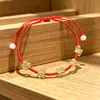 Estilo étnico, rico en color, pulsera tejida con hilo rojo mini, flor pequeña de cristal verde, año zodiacal, fabricante, joyería artesanal al por mayor