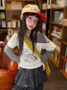 Hua Yu Xun Meninas Estilo Outono 2026 Versão Coreana Desenho Animado Falso Duas Peças Camiseta Infantil Patchwork Manga Bolinhas Ombro a Ombro Top Tendência