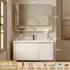 Tocador de baño engrosado y ahorrador de espacio con diseño en color crema, que cuenta con un lavabo redondeado, lavabo cerámico integrado y un lavabo de una sola pieza.