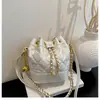 Bolso de cadena bordado con patrón de diamantes, un bolso versátil para el día a día para mujer, con cierre de cordón, un asa y un diseño que se puede llevar en la mano, al hombro o cruzado.. Es un bolso tipo cubo chic y minimalista