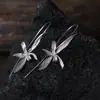 Nuevos aretes de perla y orquídea estilo chino, elegantes y refinados, con artesanía de perlas y un diseño floral fresco