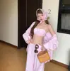 Atuendo de vacaciones relajado y casual estilo coreano para mujer: una camisa protectora del sol a rayas rosas, un top tipo camisola de moda y pantalones de pierna ancha - un conjunto de tres piezas