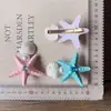 Pinza para el pelo con forma de estrella de mar y concha de perla, estilo resort costero, incrustada de diamantes, sensación de lujo ligero y alta gama, accesorio de moda para el cabello para mujer
