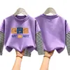 Camiseta de manga comprida para meninos, algodão puro, novo estilo primavera e outono 2026, camada interna listrada para meninos pequenos, camiseta base infantil falsa de duas peças