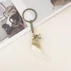 Fabricantes de chaveiros de liga metálica mais vendidos no exterior vendendo chaveiro de pena de marfim pingente decorativo para carro