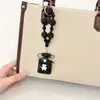 Pingente de chaveiro de garrafa de perfume com laço adornado com diamantes com corrente de contas de cristal, acessório de bolsa requintado e brilhante com diamantes, corrente para pendurar no celular