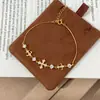 Foto real de Tiqi del minimalista brazalete de cruz de plata de ley S925 para mujer, un accesorio de nicho de lujo ligero con incrustaciones de flor de iris y diamantes, que irradia elegancia