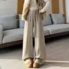 Foto real de pantalones de punto anchos para mujer con botones, flecos y bordes deshilachados, otoño/invierno 2026, de cintura alta, fluidos, pantalones rectos casuales