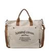 Bolsa de lona tipo tote con impresión de logo personalizado, simple y elegante para ir al trabajo, versátil para el uso diario, adecuada para estudiantes y se puede llevar como bolso de hombro o bolso de mano.